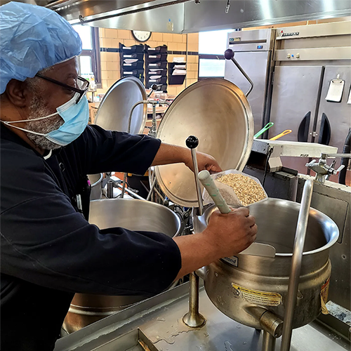 man cooks regenerative oats in a hospital kitchen